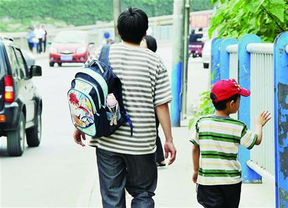 “蝸牛爸爸”任德亮和孩子走在放學回家的路上